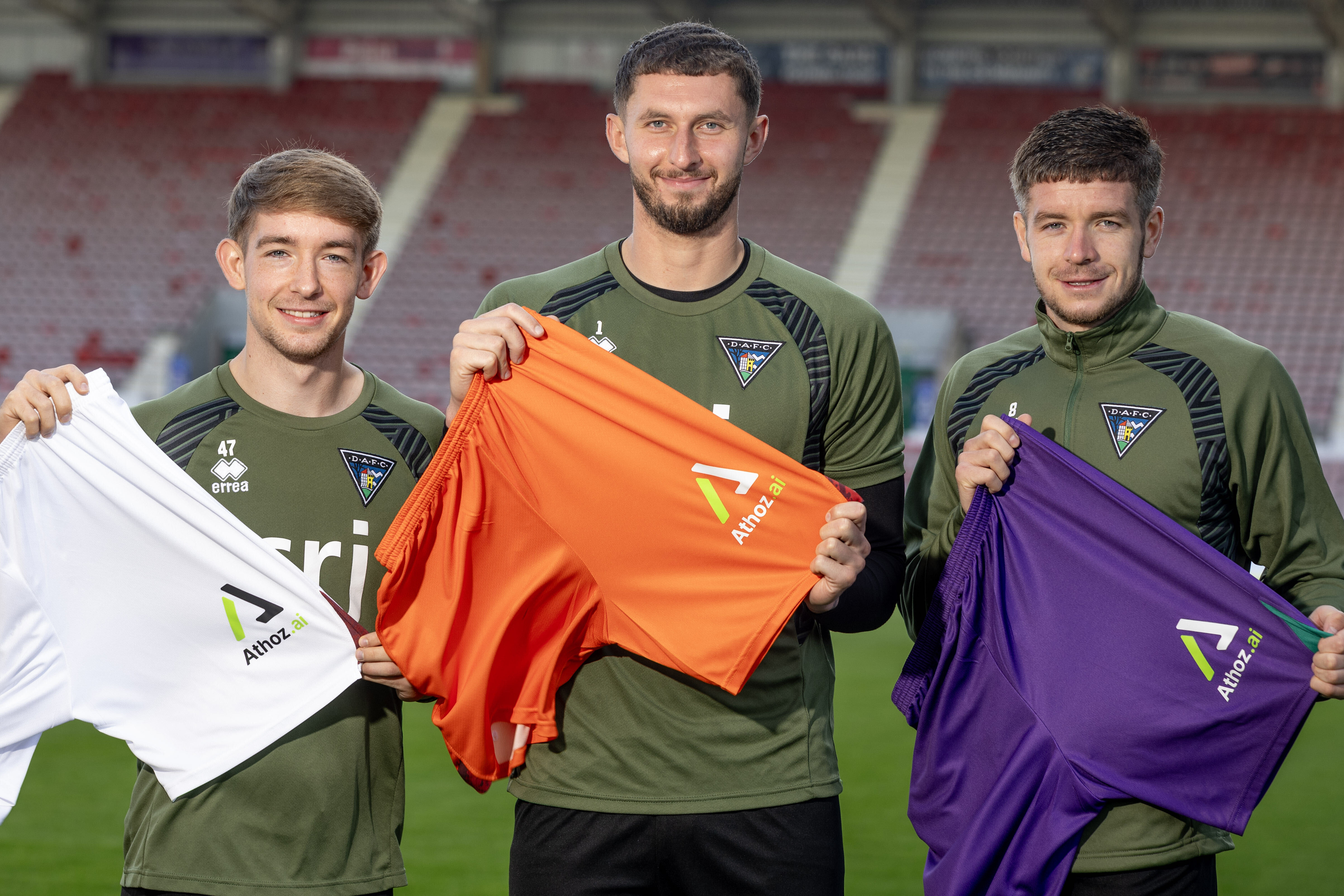 Three Dunfermline Athletic players holding shirts featuring the Athoz logo